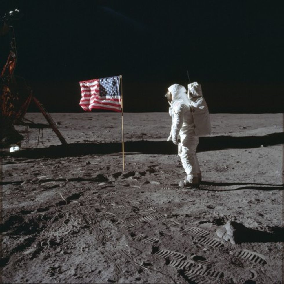 Why did the first humans to set foot off Planet Earth plant the flag of only part of Planet Earth?