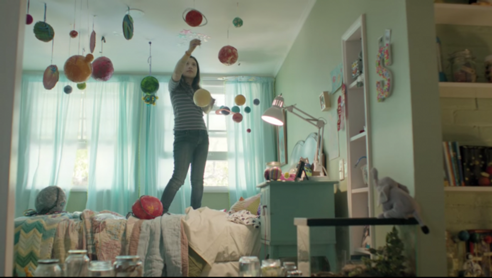 verizon ad still shows a girl hanging planets in her room